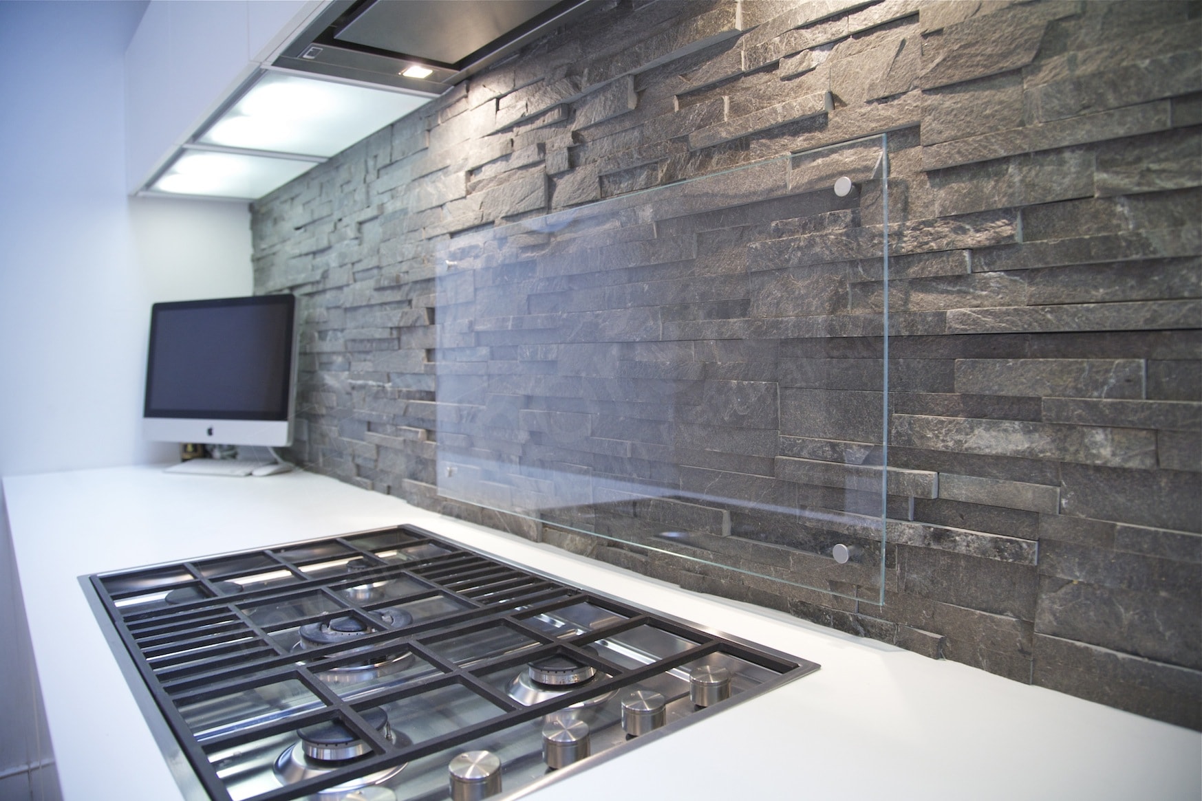 Norstone Stacked Stone Charcoal Rock Panels on a modern backsplash with a glass splatter guard